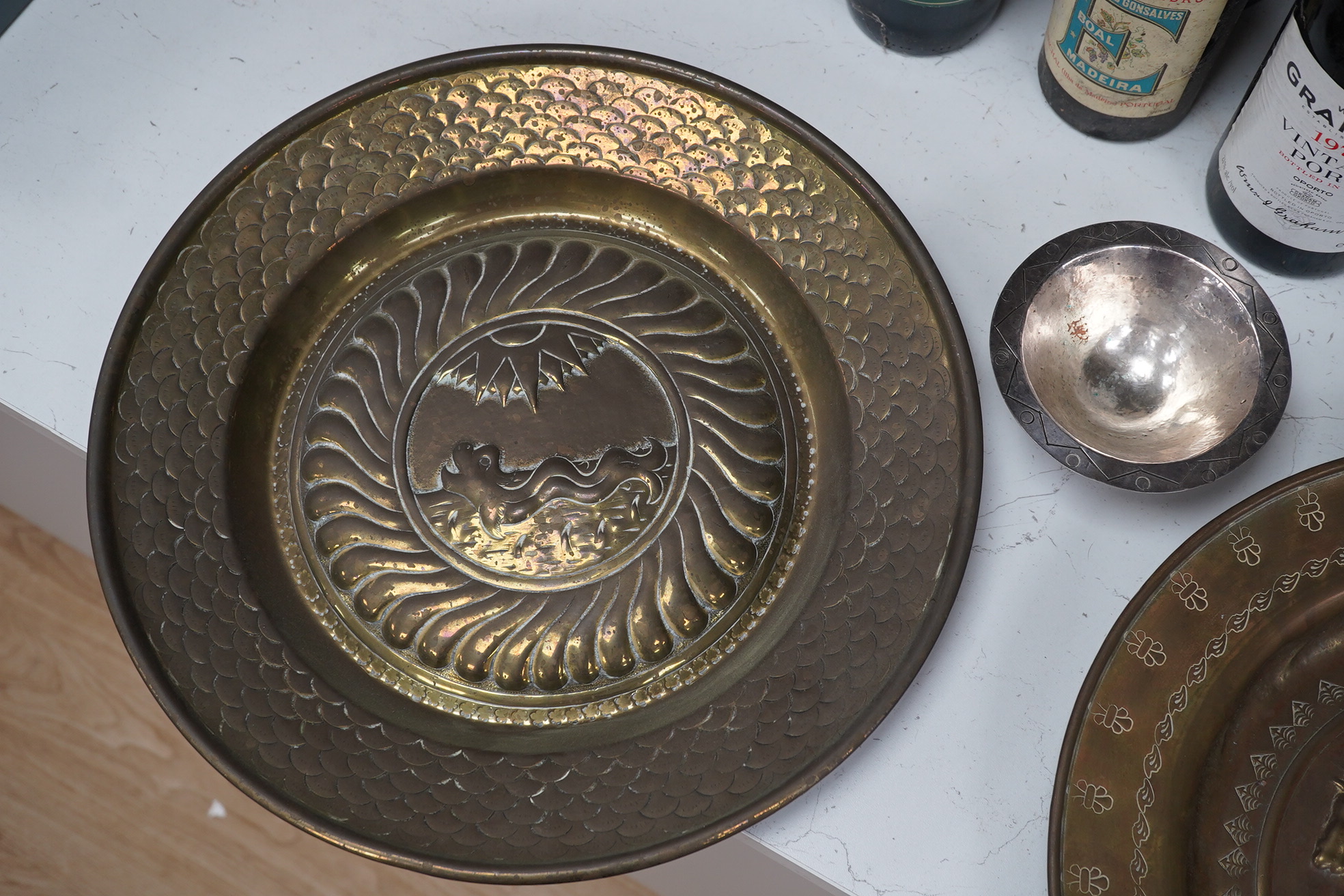 Two Nuremberg style embossed brass alms dishes and a Dresser style silver plated three footed bowl, brass dishes 36cm diameter. Condition - good